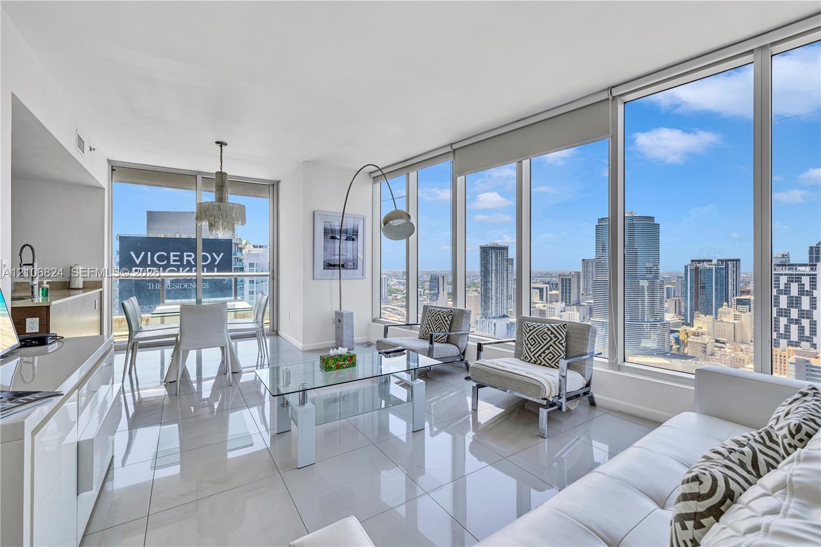 Floor-to-ceiling windows, polished tile flooring, built-in cabinetry, and pendant lighting