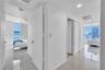 Interior hallway featuring polished tile flooring, recessed lighting, and floor-to-ceiling windows