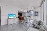 Floor-to-ceiling glass windows, polished tile flooring, kitchen with wood-finish cabinetry, and pendant lighting