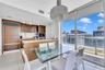 Kitchen featuring wood-finish cabinetry, stone countertops, integrated refrigerator, and porcelain tile flooring, accompanied by floor-to-ceiling wind