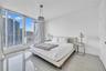Floor-to-ceiling windows, polished tile flooring, and a suspended drum pendant light fixture