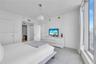 Floor-to-ceiling windows, white tile flooring, and a contemporary drum pendant light fixture