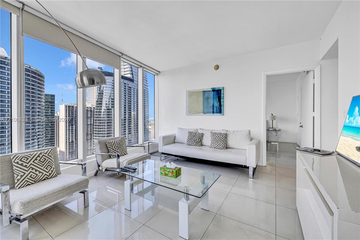 Floor-to-ceiling windows, polished tile flooring, and crisp white wall finishes
