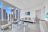 Floor-to-ceiling windows, polished tile flooring, and crisp white wall finishes