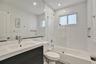 Residence 1753 (Right Side) – Bathroom 2 featuring sleek subway tile, a frameless glass shower enclosure, and a low-profile bathtub.