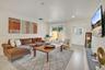Residence 1747 (Left Side) – Neutral-toned open concept living recessed LED lighting, and ample natural light from impact windows.