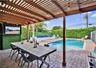 Residence 1747 (Left Side) – Covered outdoor patio featuring a wooden pergola, new flat roof, brick paver flooring, heated pool, built-in wall-mount T