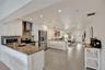 Kitchen featuring white shaker-style cabinetry, stone-surface countertops, stainless steel appliances, recessed lighting, and tile flooring