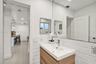 Wall-mounted vanity with a rectangular sink, polished chrome faucet, floor-to-ceiling mirror, and white subway tile wainscoting