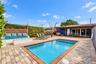 Residence 1753 (Right Side) – Private outdoor oasis featuring a heated swimming pool, built-in seating area, outdoor TV, and a pergola with a newly in