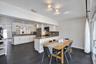 Residence 1747 (Left Side) – Kitchen featuring white cabinetry, granite countertops, stainless steel appliances, and a spacious dining area with hurri
