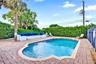 Residence 1747 (Left Side) – Private outdoor oasis featuring a heated swimming pool, built-in seating area, outdoor TV, and a pergola with a newly ins