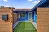 Residence 1753 (Right Side) – Private courtyard entrance featuring wood privacy fencing, and low-maintenance artificial turf and hurricane impact glas