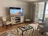 Living area featuring wood-finish flooring and expansive floor-to-ceiling glass sliding doors