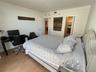 Wood-finish flooring, neutral wall finishes, and a reach-in closet with bifold doors