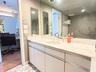 Bathroom vanity featuring a stone-top counter, dual-handle metal faucets, integrated sinks, and neutral cabinetry