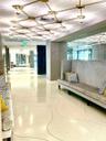 Custom grid-pattern overhead light fixture, polished terrazzo flooring with inlaid curvilinear detailing, and floor-to-ceiling mirror paneling