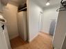 Walk-in closet featuring wood-finish flooring, built-in shelving, a full-height storage cabinet, and flush-mount ceiling lighting