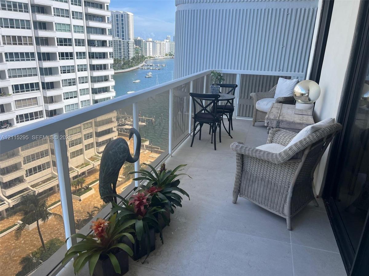 Private balcony featuring large-format tile flooring and a glass-paneled aluminum railing