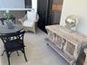 Covered balcony featuring large-format stone-finish floor tiles and white metal railing