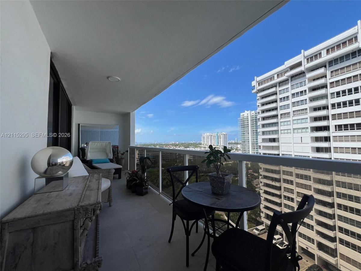 Covered balcony featuring concrete flooring and a white railing system