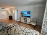 Wood-finish flooring, dual-door entry, and wall-mounted decorative lighting fixtures