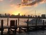 Waterfront dock featuring wooden decking and pilings with a cityscape skyline backdrop
