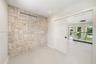 Textured stone feature wall with recessed lighting and three-panel solid core sliding door
