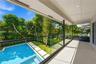Covered balcony featuring a frameless glass railing, recessed ceiling lighting, swimming pool with integrated spa, concrete paver path, and mature lan