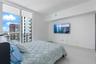 Floor-to-ceiling windows featuring access to a private balcony with metal railing and polished white flooring