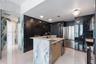 Kitchen featuring a center island with light stone-finish waterfall counters, high-gloss dark stone wall cladding, stainless steel appliances, and pol