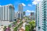 High-rise urban landscape featuring glass-facade residential towers, private balconies with glass railings, palm-lined streetscapes, and surrounding m