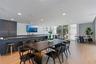 Open-concept kitchen featuring an expansive island with a stone countertop, dark cabinetry, recessed lighting, and wood-finish flooring