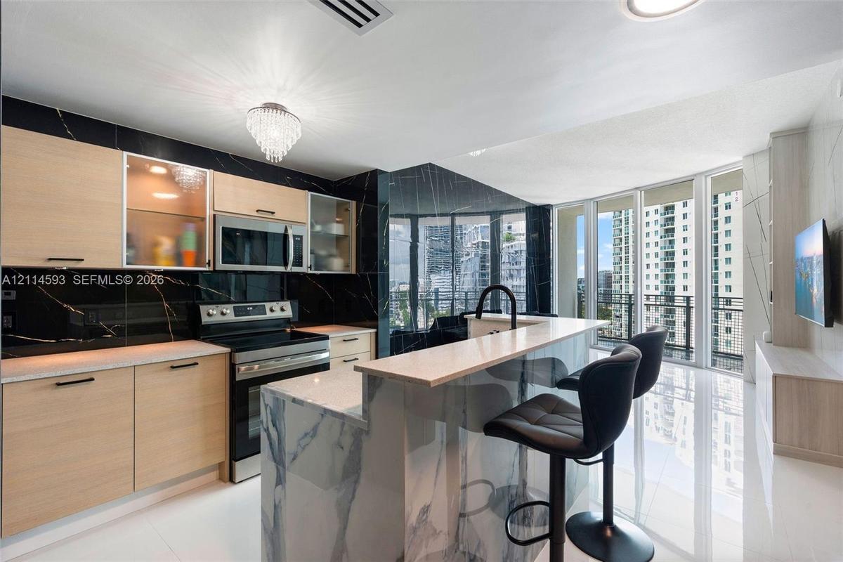Floor-to-ceiling windows, polished tile flooring, built-in cabinetry with integrated shelving, and patterned wall cladding