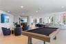 Open-concept interior featuring wood-finish flooring, recessed lighting, floor-to-ceiling windows, and a built-in wet bar with cabinetry