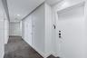 Hallway featuring neutral-toned carpeting, recessed ceiling lighting, and solid-core interior doors with metallic lever hardware
