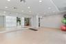 Large wall-mounted mirror, light-toned wood-finish flooring, and recessed ceiling lighting