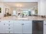 Custom Cucina with a Grand Peninsula, Quartzite Counter & Backsplash Accessorized Stainless Appliances.