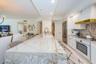 Custom Cucina with a Grand Peninsula, Quartzite Counter & Backsplash Accessorized Stainless Appliances.