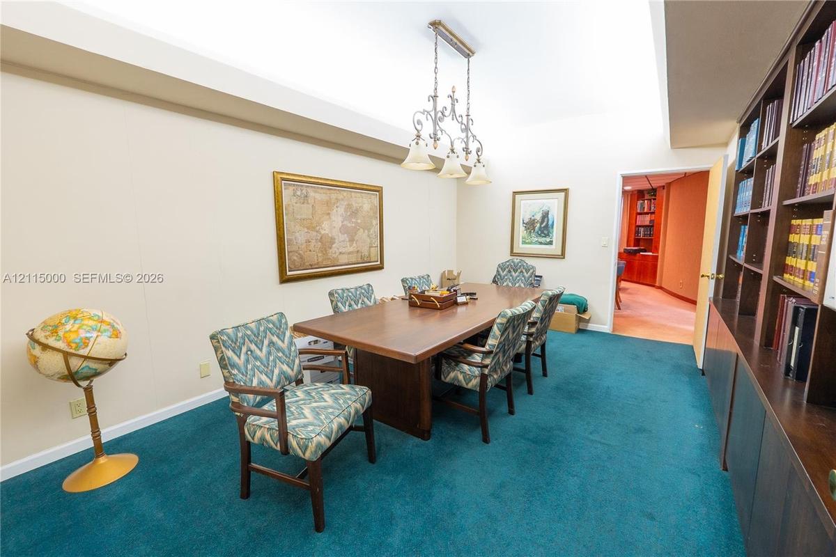 Built-in floor-to-ceiling wood shelving, multi-arm metal chandelier, and recessed ceiling lighting