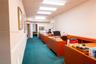 Built-in wood shelving, decorative metal chandelier, and high-contrast carpeting