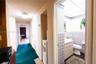 Bathroom featuring patterned wall tiling, a gold-toned faucet, a built-in vanity, a wall-mounted mirrored medicine cabinet, and a drop-in sink