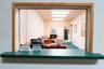 Built-in laminate desk stations, wall-to-wall carpeting, multiple linear ceiling-mounted light fixtures, and neutral wall finishes