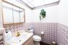 Built-in floor-to-ceiling wooden shelving and dual rectangular surface-mount lighting fixtures