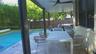 Covered patio with recessed lighting and ceiling fans, stone paver decking, and in-ground swimming pool with privacy fencing