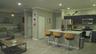 Kitchen featuring dark cabinetry, stone-finish countertops, stainless steel appliances, a central island with bar seating, and wood-finish flooring