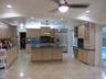 Kitchen featuring light wood cabinetry, center island, stone countertops, stainless steel appliances, and integrated wine rack