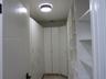 Custom floor-to-ceiling cabinetry featuring white laminate finish, adjustable shelving, integrated storage drawers, gold-toned hardware, and a circula