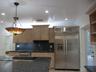 Kitchen featuring natural wood-finish cabinetry, dark stone countertops, recessed ceiling lighting, stainless steel side-by-side refrigerator, and a d