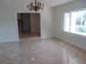Polished stone tile flooring, ornate multi-arm chandelier, and expansive picture window